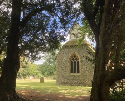 St Lawrence church, Cholesbury St Lawrence Church, viewed through woodlands, bathed in sunlight