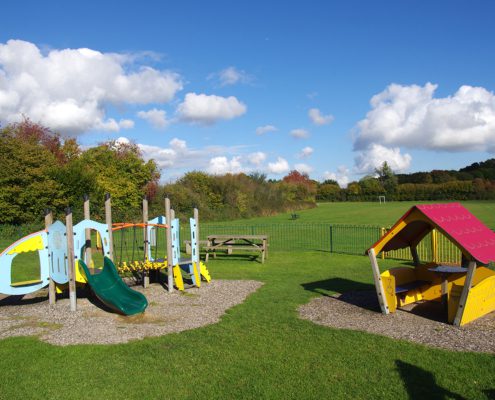 Play equipment at Codmore Fields, view of playing field behind