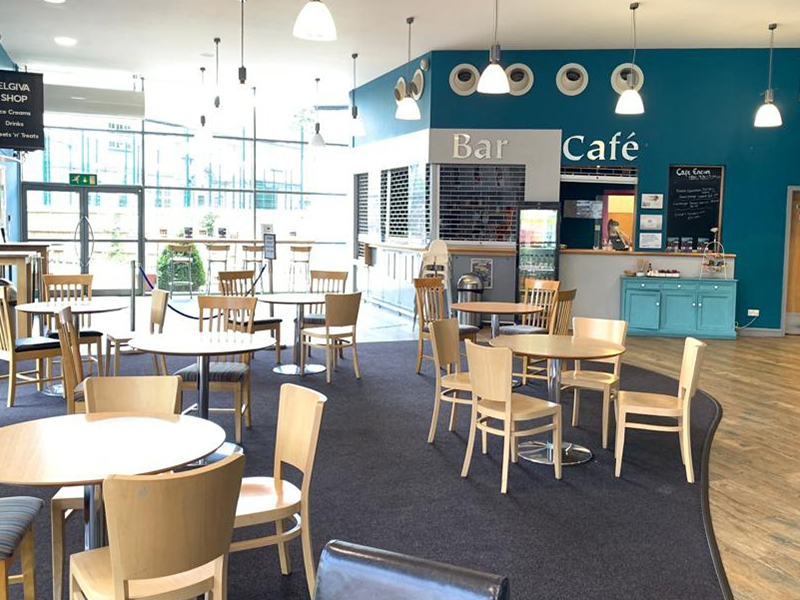 Seating at round tables in Elgiva foyer with cafe to the back right
