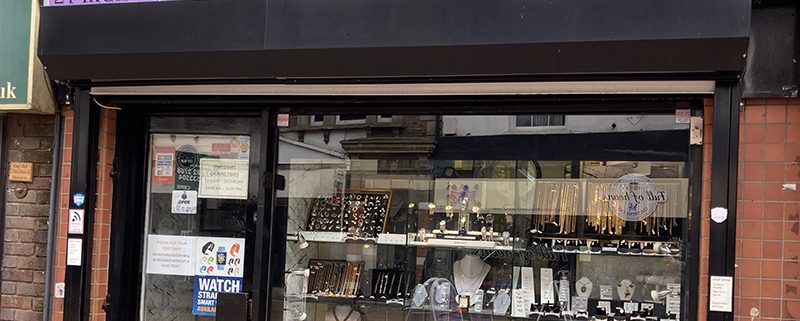 Shop front of Gold and Jewels – bright purple signage with gold type, and window display of jewellery and watches