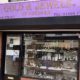 Shop front of Gold and Jewels – bright purple signage with gold type, and window display of jewellery and watches