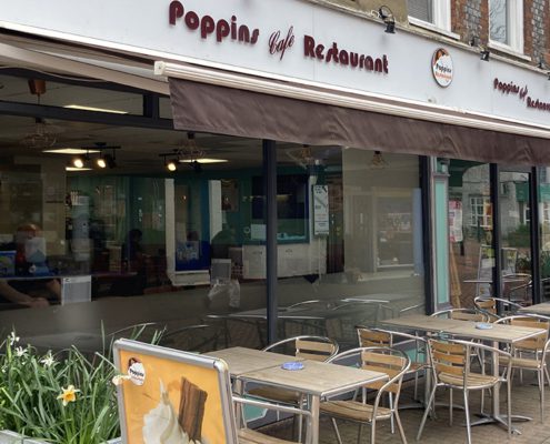 Exterior of Poppins with seating outside and daffodils in foreground