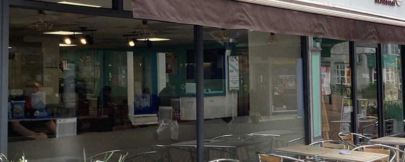 Exterior of Poppins with seating outside and daffodils in foreground