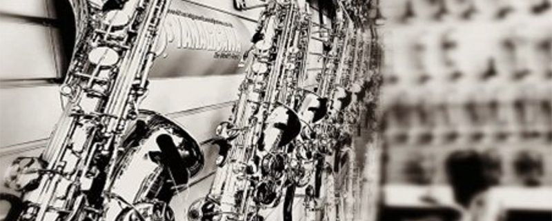 Monchrome image of close up of saxophones hanging on a wall