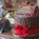 Tall handmade chocolate cake and wrapped in red ribbon.