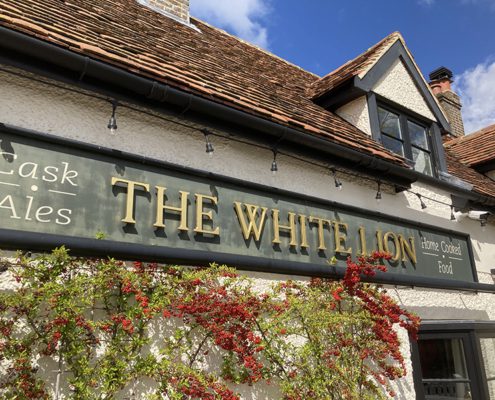 Front of White Lion pub with foliage and red berries