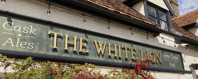 Front of White Lion pub with foliage and red berries