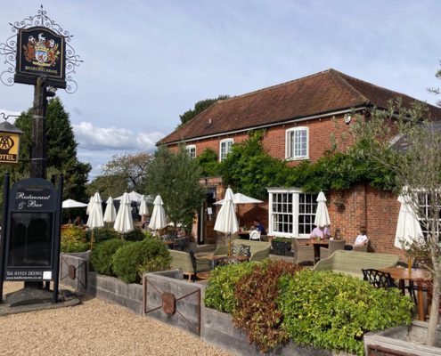 Outside view of the Bedford Arms pub, Chenies, with pub sign and garden area.