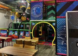indoor soft play area with wooden tables in foreground