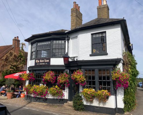 Exterior of the red Lion pub in Chenies, with hanging baskets