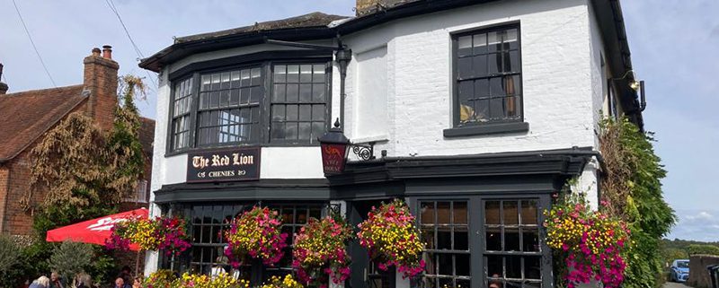 Exterior of the red Lion pub in Chenies, with hanging baskets