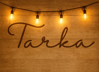 Tarka in cursive text on wooden panel with four fairy lights above