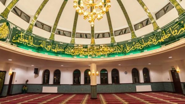 Interior or mosque showing dome, chandelier and partial inscription
