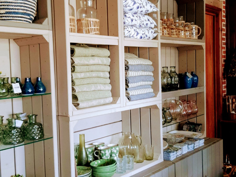 Muted earthy coloured blankets and ceramics on wooden selving